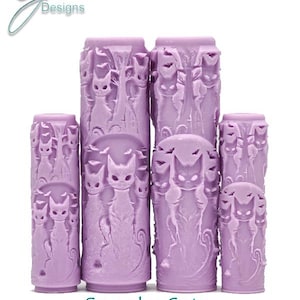 May include: Set of four purple rubber rollers featuring an intricate design of spooky cats. The rollers are of varying sizes and have a textured surface. The text "Spooky Cats Intricate Texture" is printed below the rollers.