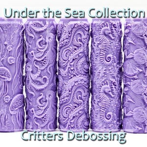 Puede incluir: Conjunto de cuatro rodillos de amasar de color morado con diferentes diseños de criaturas marinas. Los diseños incluyen medusas, pulpos, caballitos de mar y tortugas marinas. Los rodillos de amasar están etiquetados como "Under the Sea Collection" y "Critters Debossing".