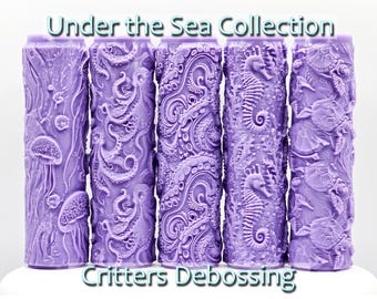May include: Set of four purple rolling pins with different sea creature designs. The designs include jellyfish, octopus, seahorse, and sea turtles. The rolling pins are labeled "Under the Sea Collection" and "Critters Debossing".