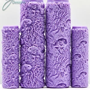 May include: Four purple textured paint rollers with a design of clownfish and coral. The rollers are different sizes. The text "Clownfish Intricate Texture" is below the rollers.