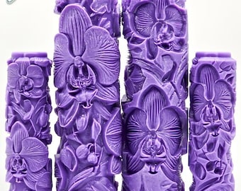 May include: Four purple patterned paint rollers featuring an embossed orchid floral design. The rollers display the text G Designs, Orchid, and UltraDeep Texture. These cylindrical tools have a deep relief pattern for surface texturing.