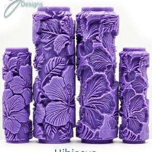 May include: Four purple textured paint rollers with a hibiscus flower design. The rollers are labeled "Hibiscus Ultra Deep Texture".