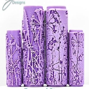 May include: Four cylindrical, lilac-coloured texture rollers with pressed stem designs. The rollers vary in height and feature intricate floral patterns. The text "Pressed Stems Intricate Texture" is at the bottom. The rollers are on a white background.