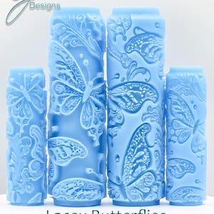 May include: Four light blue cylindrical rollers featuring butterfly and floral designs. The rollers are embossed with detailed butterfly wings and decorative patterns. The text "Lacey Butterflies Deep Texture" is at the bottom.