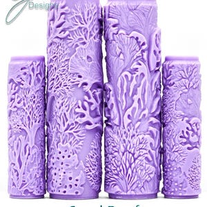 Pode incluir: Quatro rolos de pintura cilíndricos roxos com um padrão de recife de coral em relevo. Os rolos exibem texturas complexas de várias formas de vida marinha, incluindo corais ramificados. O texto G Designs, Coral Reef e Intricate Texture aparece.