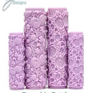 May include: Four purple rolling pins with an intricate pumpkin patch design. The rolling pins are different sizes and are arranged in a row from largest to smallest.
