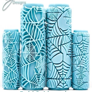 May include: Four light blue cylindrical rollers with a raised spiderweb pattern. The two larger rollers are in the centre, flanked by two smaller rollers. The text "G Designs" appears in the top left, and "Bold Spiderwebs Deep Impression" is at the bottom.