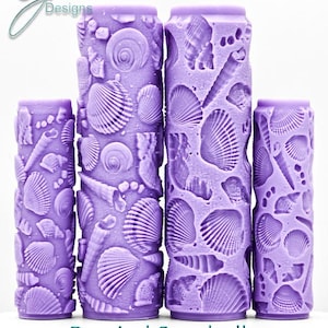 May include: Four cylindrical purple rollers featuring an embossed pattern of various seashells. The text G Designs appears in the top left corner, and the text Burried Seashells Intricate Texture is printed at the bottom of the image.