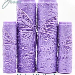 Könnte beinhalten: Vier violette Gummistempel mit einem geätzten Schmetterlingsdesign. Die Stempel sind in verschiedenen Größen und haben eine strukturierte Oberfläche. "Etched Butterfly Intricate Texture" steht unter den Stempeln.