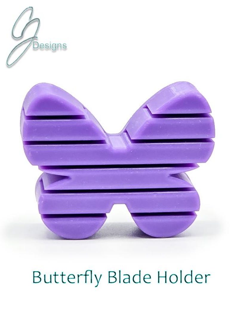 May include: Purple plastic butterfly-shaped blade holder.  The holder has a striped design.