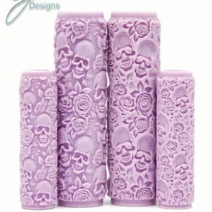 Könnte beinhalten: Vier violette, strukturierte Farbrollen mit einem Totenkopf- und Rosenmuster. Die Rollen sind mit "Skulls n Roses Intricate Texture" beschriftet.