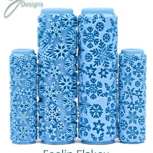 Puede incluir: Cuatro rodillos de pintura azules con un patrón de copo de nieve. Los rodillos son de diferentes tamaños y están dispuestos del más grande al más pequeño. El texto "Feelin Flakey Deep Texture" está debajo de los rodillos.