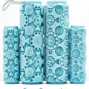 Può includere: Una collezione di strumenti cilindrici azzurri con intricati motivi geometrici. Gli strumenti presentano disegni ripetuti di spirali, stelle e nodi celtici. Il testo "Crop Geometry Deep Impression" è visualizzato sotto.