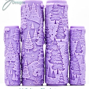 May include: Four cylindrical purple paint rollers featuring an embossed pattern of a winter forest with pine trees and snow. The text G Designs appears in the top left, and White Christmas Intricate Texture is printed at the bottom.