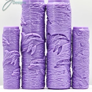May include: Four purple textured paint rollers with a dolphin design. The rollers are arranged in a row from largest to smallest. The text "Dolphins Intricate Texture" is printed below the rollers.