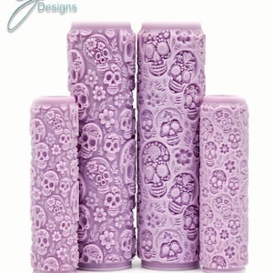 May include: Set of four purple rolling pins with a sugar skull and floral design. The rolling pins are different sizes. "Sugar Skulls Intricate Texture" is written below the rolling pins.