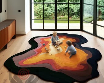 Puede incluir: Una alfombra multicapa de forma orgánica, con un degradado de colores que va del negro al amarillo. La alfombra está colocada sobre un suelo de madera, con dos niños jugando sobre ella. La habitación tiene grandes ventanales con vistas a un espacio exterior verde.