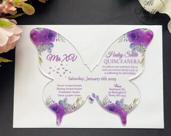 Könnte beinhalten: Eine violette und weiße, schmetterlingsförmige Acryleinladung zu einer Quinceañera. Die Einladung enthält den Text "Mis XV" und "Hailey Smith Quinceañera". Der Text lautet: "Es ist uns eine Freude und Ehre, Sie und Ihre Familie einzuladen, um mit uns den 15. Geburtstag von Hailey zu feiern. Samstag, 6. Januar 2029. Abendessen: 18:00-20:00 Uhr, Segnung: 20:00-20:30 Uhr, Präsentation: 20:30 Uhr, Tanz: 21:30-1:00 Uhr. Veranstaltungsort: Beachmont View, 150 Bennington St, Revere, MA 02151."