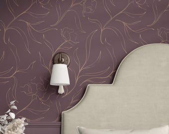 Op de afbeelding: Een donker mauve behang met een doorlopend goudkleurig lijnpatroon van bloemstengels en bladeren. Een wandlamp met een donkerbruine voet en een witte, verticaal geribbelde, conische kap is boven het behang met patroon geplaatst.