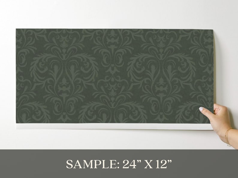 The product is a 24 by 12 inch rectangular wallpaper sample made from paper-based material. It has a dark green matte finish with a tone-on-tone damask pattern in a slightly darker shade. The pattern forms a repeating arrangement of symmetrical, ornate motifs. The surface shows a subtle, raised texture along the pattern lines.
