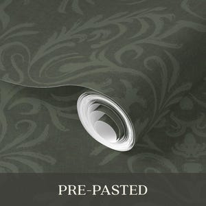 The product is a cylindrical roll of pre-pasted wallpaper in dark green with a tonal floral damask pattern. The surface is smooth with a slight sheen on a vinyl-coated paper substrate. The roll is tightly wound, indicating it is unused, and features a repeating, intricate design.
