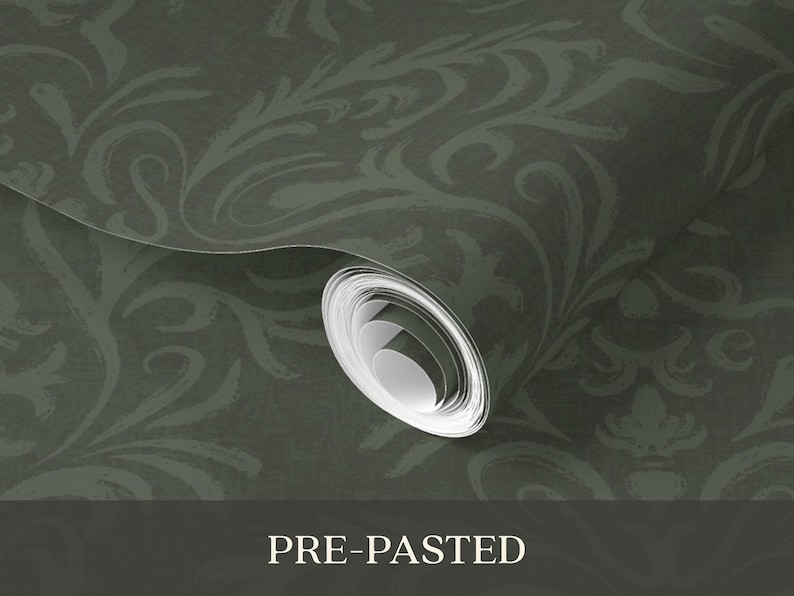 The product is a cylindrical roll of pre-pasted wallpaper in dark green with a tonal floral damask pattern. The surface is smooth with a slight sheen on a vinyl-coated paper substrate. The roll is tightly wound, indicating it is unused, and features a repeating, intricate design.