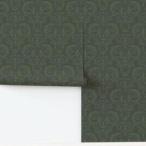 A dark green rectangular panel of fabric or wallpaper features a repeating damask pattern in a slightly lighter green. The symmetrical floral and scroll motifs are intricately detailed, creating a subtle contrast. The surface looks smooth with no visible texture variation. The straight edges suggest standard cut dimensions.