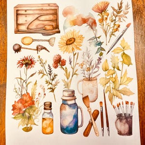 May include: A sheet of planner stickers titled Vintage Antique Planner Stickers featuring watercolor illustrations of a wooden box, a sunflower, wildflowers, paintbrushes in a cup, a glass jar, and a bottle. The bottom text reads JKiser.LuvinbyJessica.etsy All about the HOme!
