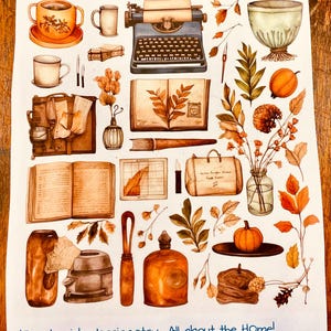 May include: A sticker sheet titled Vintage Antique Planner Stickers featuring illustrations of a typewriter, open books, mugs, pumpkins, autumn leaves, a glass vase, and a suitcase. The bottom text reads JKiser.LuvinbyJessica.etsy All about the HOme!