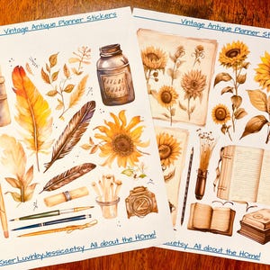 May include: Two sheets of planner stickers titled Vintage Antique Planner Stickers and JKiser LuvinbyJessicaetsy All about the HOme!. The stickers feature watercolor illustrations of sunflowers, feathers, ink bottles, paintbrushes, pencils, and open books in shades of brown, yellow, and gold.