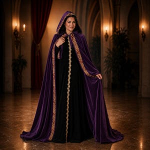 May include: A floor-length purple velvet hooded cloak featuring a decorative gold and red patterned trim along the front edges and hood opening. The cloak is worn over a simple black long-sleeved dress, creating a layered appearance with a hood.
