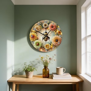 May include: A round wall clock featuring a central illustration of a bee surrounded by a circular arrangement of colorful flowers in shades of yellow, orange, and green. The clock face displays black numbers from one to twelve and black hands.