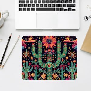 May include: A colorful mousepad with a repeating pattern of cacti, flowers, and stars on a dark blue background.