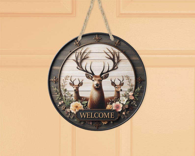 Op de afbeelding: Ronde houten welkomstbord met een hertenfamilie met grote geweien en bloemaccenten. Het bord heeft een donkerbruine rand en een lichtbruine achtergrond met het woord "WELCOME" onderaan. Een natuurlijk touw wordt gebruikt om op te hangen.