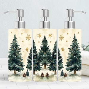May include: Three decorative soap dispensers with silver pumps. Each dispenser features a watercolor design of evergreen trees, snowflakes, and stars on a cream background. The base of each dispenser has pine cones and snow.