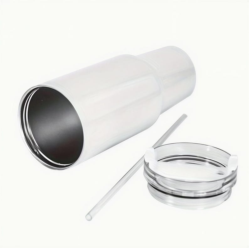 A white, cylindrical container with a clear lid and a straw lying next to it.