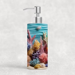 May include: A rectangular soap dispenser with a silver pump. The dispenser features a colorful underwater scene with coral, seashells, and a small white fish. The design includes shades of blue, pink, yellow, and purple.