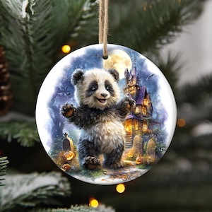 A panda bear ornament hanging on a Christmas tree, depicting a castle and a full moon.