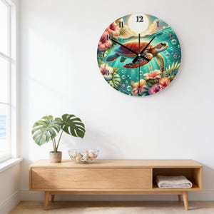 May include: A round wall clock featuring a vibrant underwater scene with a sea turtle swimming among colorful hibiscus flowers and bubbles. The clock face displays black numbers from 1 to 12 and black hour, minute, and second hands.