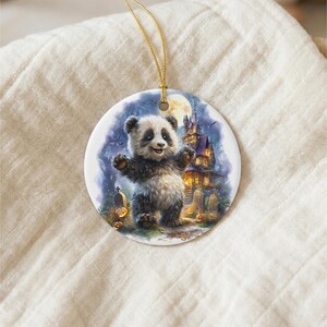A panda bear standing on a grassy field with a castle in the background, as depicted on a circular ornament.