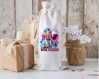 May include: White wine bottle bag with a colorful illustration of a woman in a robe holding a glass of red wine. The text "Wine O'Clock!" is printed on the bag.