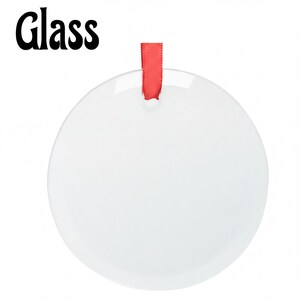 A white, round ornament with a red ribbon hanging from it.
