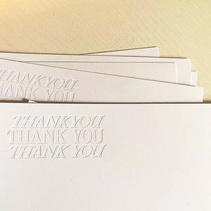 以下が含まれることがあります： 各カードに「THANK YOU」というエンボス加工が施された白いサンキューカードの束
