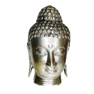 May include: Silver-toned metal sculpture of a Buddha head with closed eyes. The head is detailed with a textured pattern and a small dot on the forehead.