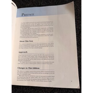 Op de afbeelding: Pagina uit een open boek met de titel "PREFACE". De tekst beschrijft de inhoud van een programmeercursus, inclusief objectgeori&euml;nteerde taal, probleemoplossing en relationele databases. De pagina is wit met zwarte tekst.