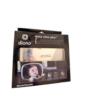 Puede incluir: Una caja negra con la marca "diono" y el texto "easy view plus". La caja contiene un espejo retrovisor con luz con control remoto. La caja también tiene una foto de un bebé en el espejo.