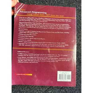 Op de afbeelding: Een boek getiteld "Advanced Programming Using Visual Basic .NET" met een rode en gele omslag. De omslag van het boek bevat tekst die de inhoud en kenmerken van het boek beschrijft, inclusief databaseverwerking en webdiensten.