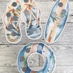 May include: Four beach-themed scratch-off cards. Two flip-flop cards, a surfboard card, and a round floatie card. Each card has silver scratch-off circles. The flip-flops and surfboard have a watercolor design. The text "BUDGET WITH MAMA BEAR" is on the cards.