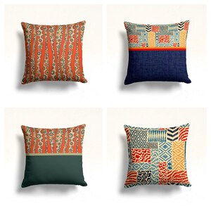 Può includere: Quattro cuscini decorativi con diversi motivi geometrici. I cuscini sono tutti quadrati e hanno uno sfondo bianco. I motivi sono in tonalità di arancione, blu, rosso e giallo.