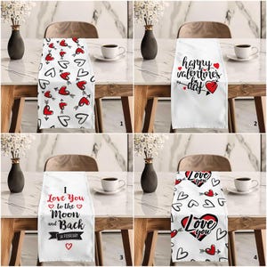 May include: Four different Valentine's Day table runners with various designs. The first runner features red hearts and arrows. The second runner says "Happy Valentine's Day". The third runner says "I Love You to the Moon and Back 14 February". The fourth runner features red hearts, arrows, and the text "Love You".